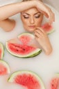 Girl enjoys a bath with milk and watermelon. Royalty Free Stock Photo
