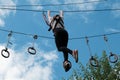 A girl enjoys climbing in the ropes course adventure. Climbing high wire park. Copy space for your text.