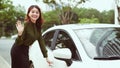 Girl entering the car off to road concept urban lifestyle smiling and waving leaving