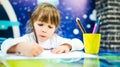 Girl enthusiastically draws with pencils Royalty Free Stock Photo