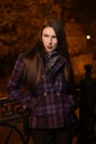 girl in the evening at night in the city on the street, cool, cold, with a round natural face, fashion, autumn