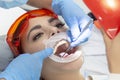 Girl on examination at dentist. treatment of carious tooth. the doctor uses a mirror on the handle and a boron machine