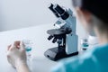 a girl examines water samples with a microscope, a water quality testing laboratory, copy space. Generative AI Royalty Free Stock Photo