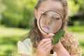 Girl examining leaf with magnifying glass at park Royalty Free Stock Photo