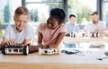 Girl examining the wheel of her friends robotic vehicle Royalty Free Stock Photo