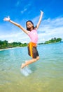 girl excited, jumping in the air at the beach