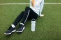 Girl after exercise, drinking water on the football field. Portrait of beautiful girl in sportswear. Royalty Free Stock Photo