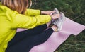 Girl exercising outdoors in sun summer day, fitness woman in trainer stretching exercises legs training outside on green park Royalty Free Stock Photo