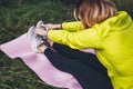 Girl exercising outdoors on yoga mat, fitness woman sneaker stretching exercises legs training outside on green grass. Sportswoman Royalty Free Stock Photo