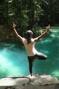 Girl exercising yoga in Kali biru Warsambin - Blue River Royalty Free Stock Photo