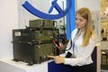 Girl exhibitor presenting made in Ukraine military radio transmitter placed on a stand. Exhibition Arms and Safety