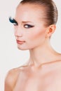 Girl with fake eyelashes and colourful eyeshadow side view face hair tied back