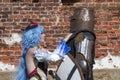 A girl in a fantasy costume says goodbye to a medieval knight