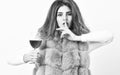 Girl fashion makeup wear fur coat hold wine glass. Alcohol and cold weather. Woman enjoy wine. Hedonism concept. Lady