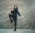 Girl in fashionable black casual clothes on background of stone wall, modern urban architecture, vogue style photo Royalty Free Stock Photo