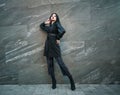 Girl in fashionable black casual clothes on background of stone wall, modern urban architecture, vogue style photo Royalty Free Stock Photo