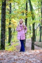 Girl fashionable blonde walk in autumn forest. Woman wear warm pink jacket. Jackets everyone should have. Best puffer