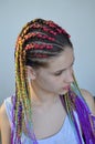 A girl with a fashionable set of multicolored braids Kanekalon. Colored artificial strands of hair.