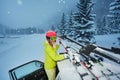 Girl fastening skis on car roof in the evening