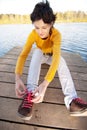 Girl fastens laces on gym shoes Royalty Free Stock Photo