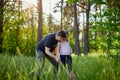 A girl with father catches butterflies with a pink juice on a summer day Royalty Free Stock Photo