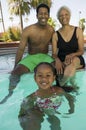 Girl (5-6) with father and grandmother at swimming pool portrait.