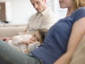 Girl With Father And Mother Relaxing At Home