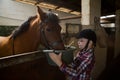 Girl feeding the horse in the stable Royalty Free Stock Photo