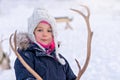 Girl feeding reindeer in the winter