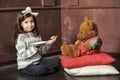 Girl feeding a teddy bear Royalty Free Stock Photo