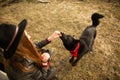 Girl feeds her black dog Brovko Vivchar in fron of old wooden house Royalty Free Stock Photo