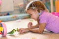 The girl feeds parrot fresh grass. budgerigar