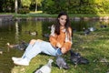 A girl feeds pigeons on the shore of a pond Royalty Free Stock Photo