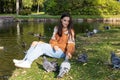 A girl feeds pigeons on the shore of a pond Royalty Free Stock Photo