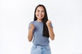 Girl feeling happy, relieved as achieve opportunity show herself. Attractive smiling asian woman fist pump, triumphing