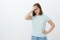 Girl feeling humiliated seeing mom near university. Awkward displeased and embarrassed cute young woman in t-shirt Royalty Free Stock Photo