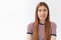 Girl feeling scared of consequences, look embarrassed and nervous, cringe face and clench teeth, frowning bothered Royalty Free Stock Photo