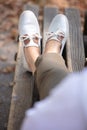 girl feet in lightweight summer shoes on wooden bench Royalty Free Stock Photo