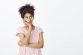 Girl feleing homesick and bored. Portrait of gloomy cute woman in glasses and striped t-shirt, leaning head on hand and Royalty Free Stock Photo