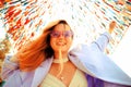 A girl at the festival looks at the camera and smiles against the background of a colorful background, dancing in purple glasses Royalty Free Stock Photo