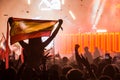 Girl at a festival with a Spanish flag on the shoulders overlooking the crowd