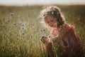 Girl in a field collects a bouquet of flowers. little girl collects flowers in the field Royalty Free Stock Photo