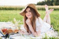 Girl in a field with daisies, summer in the village.Young smiling woman relaxing outdoors and having a picnic, she is Royalty Free Stock Photo