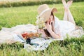 Girl in a field with daisies, summer in the village.Young smiling woman relaxing outdoors and having a picnic, she is Royalty Free Stock Photo
