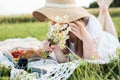 Girl in a field with daisies, summer in the village.Young smiling woman relaxing outdoors and having a picnic, she is Royalty Free Stock Photo