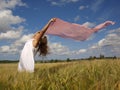 Girl in a field with a pink scarf