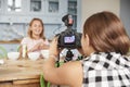 Girl filming her friend for cookery video blog in kitchen Royalty Free Stock Photo