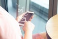 girl and finger touch smartphone on screen in coffee shop with furniture background in social network messege email Royalty Free Stock Photo