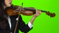 Girl fingering the strings playing on a violin. Close up. Green screen