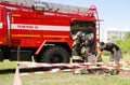 Girl in fireman`s suit against a fire engine preparing to overc